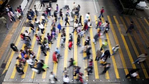 People cross a busy street in Hong Kong