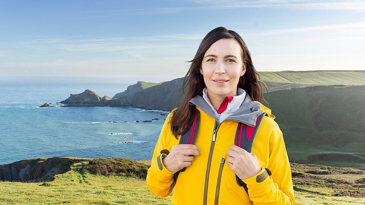Woman standing in the mountain with bags