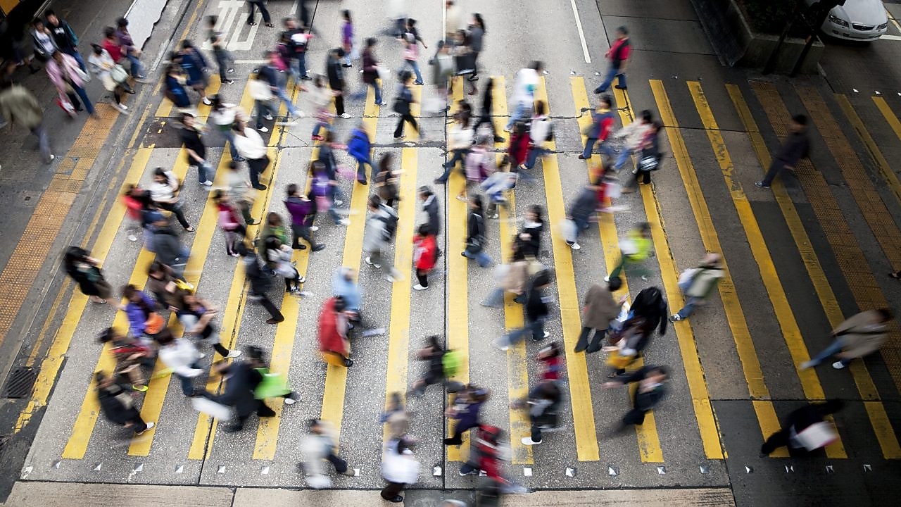 People cross a busy street in Hong Kong