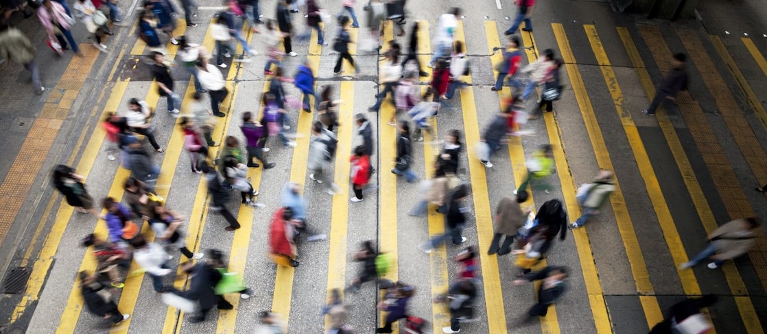 People cross a busy street in Hong Kong
