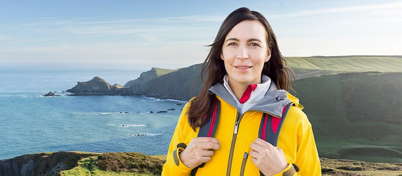 Woman standing in the mountain with bags