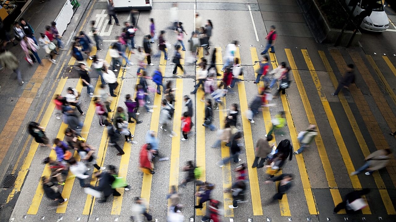 People cross a busy street in Hong Kong