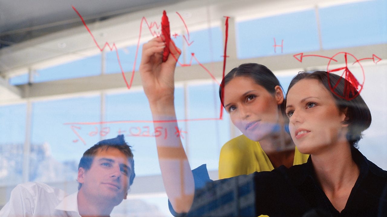 Businesswoman drawing graphs on glass