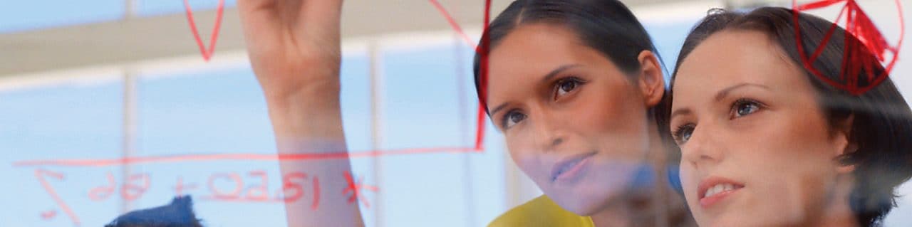 Businesswoman drawing graphs on glass